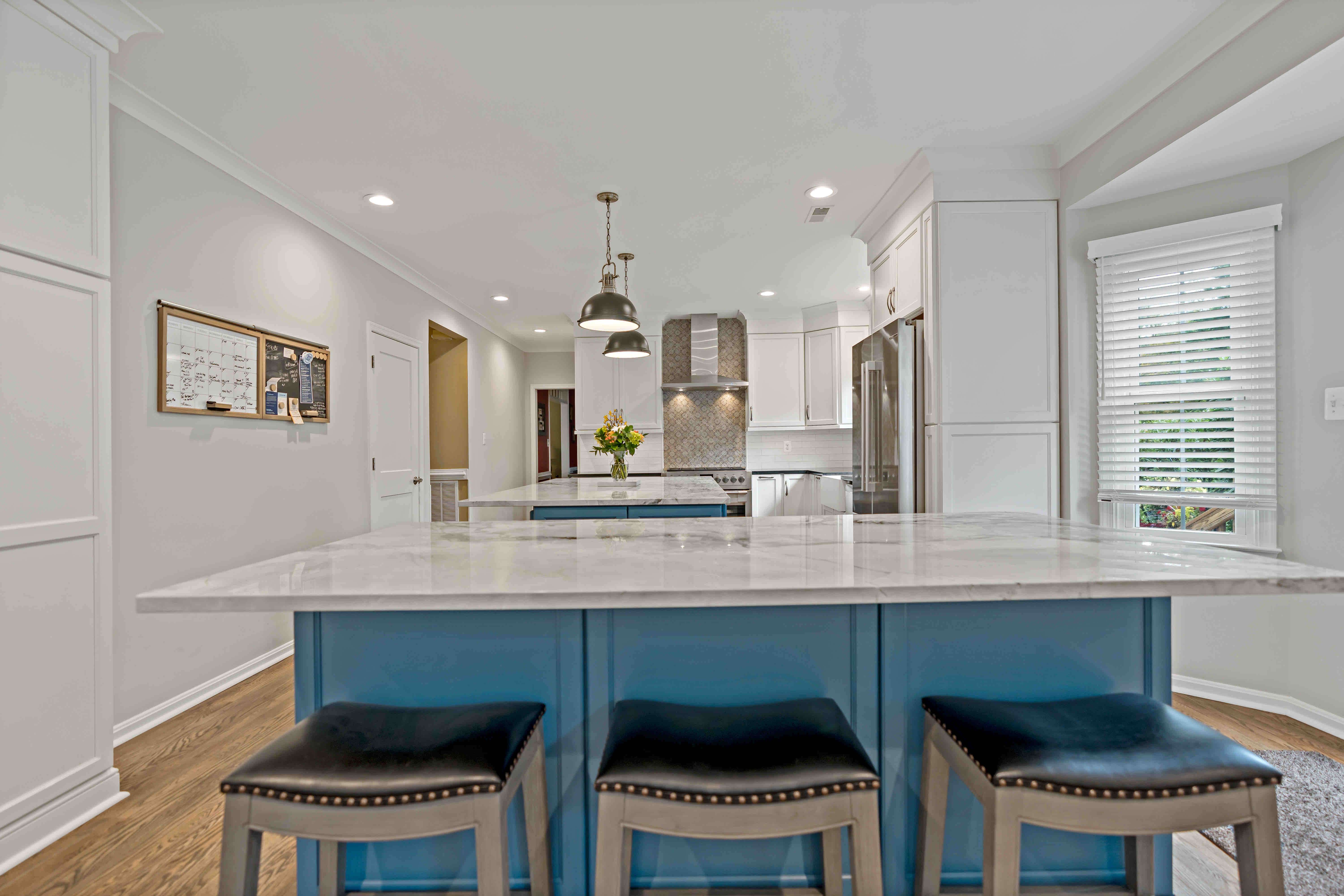 Blue kitchen island with black and white marble countertop