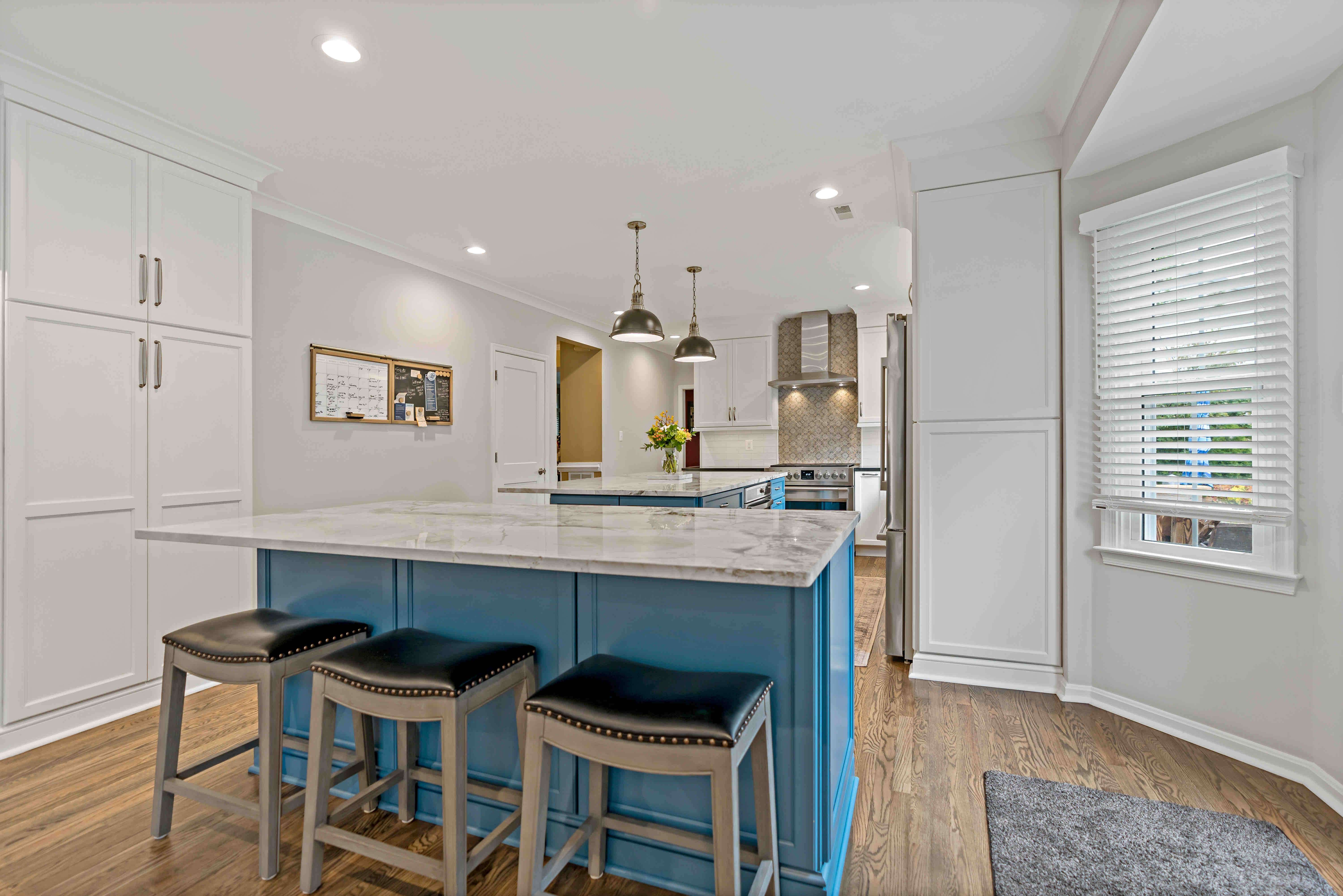 Two islands with seating in blue kitchen remodel