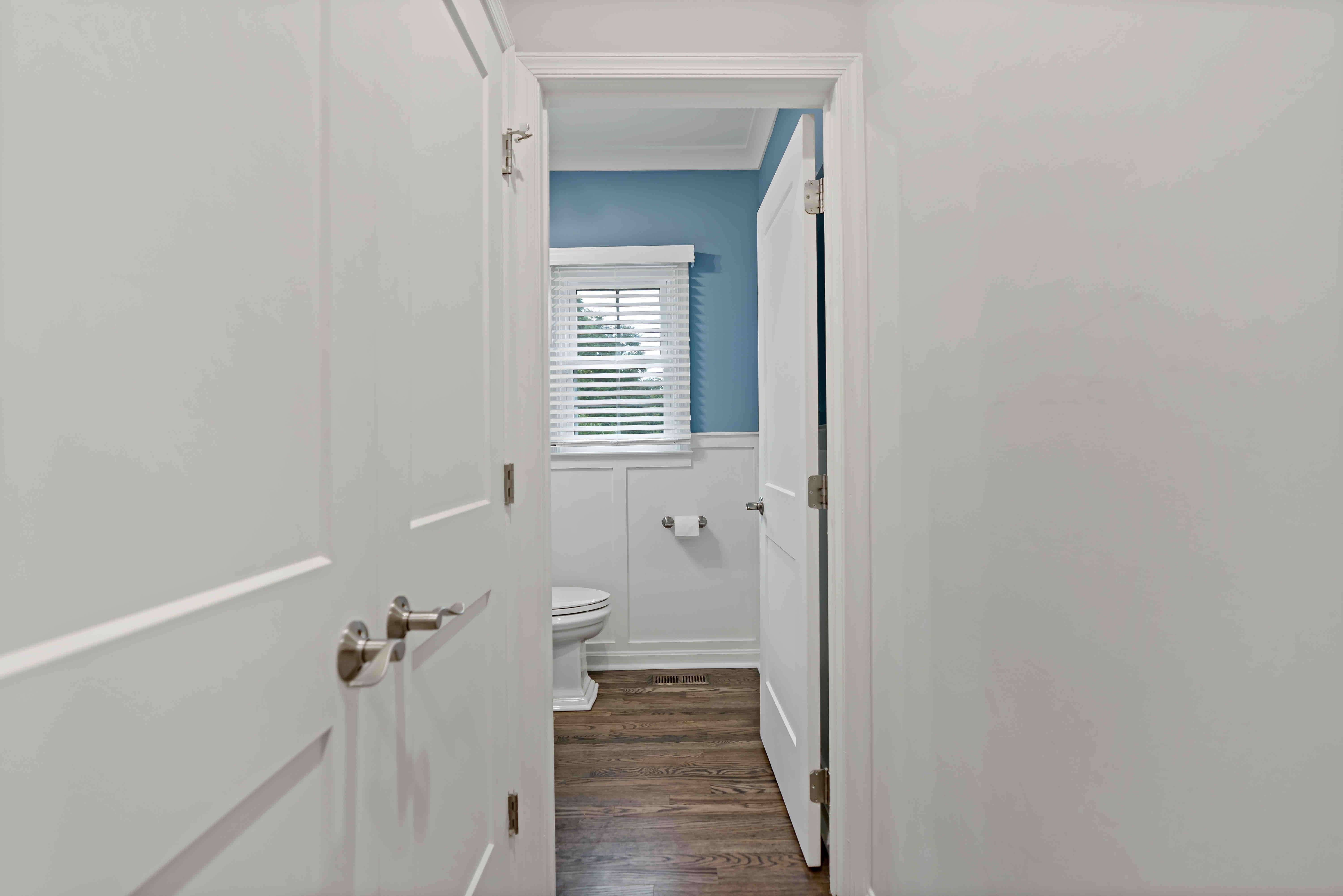 Entrance to small bathroom with hard wood floors