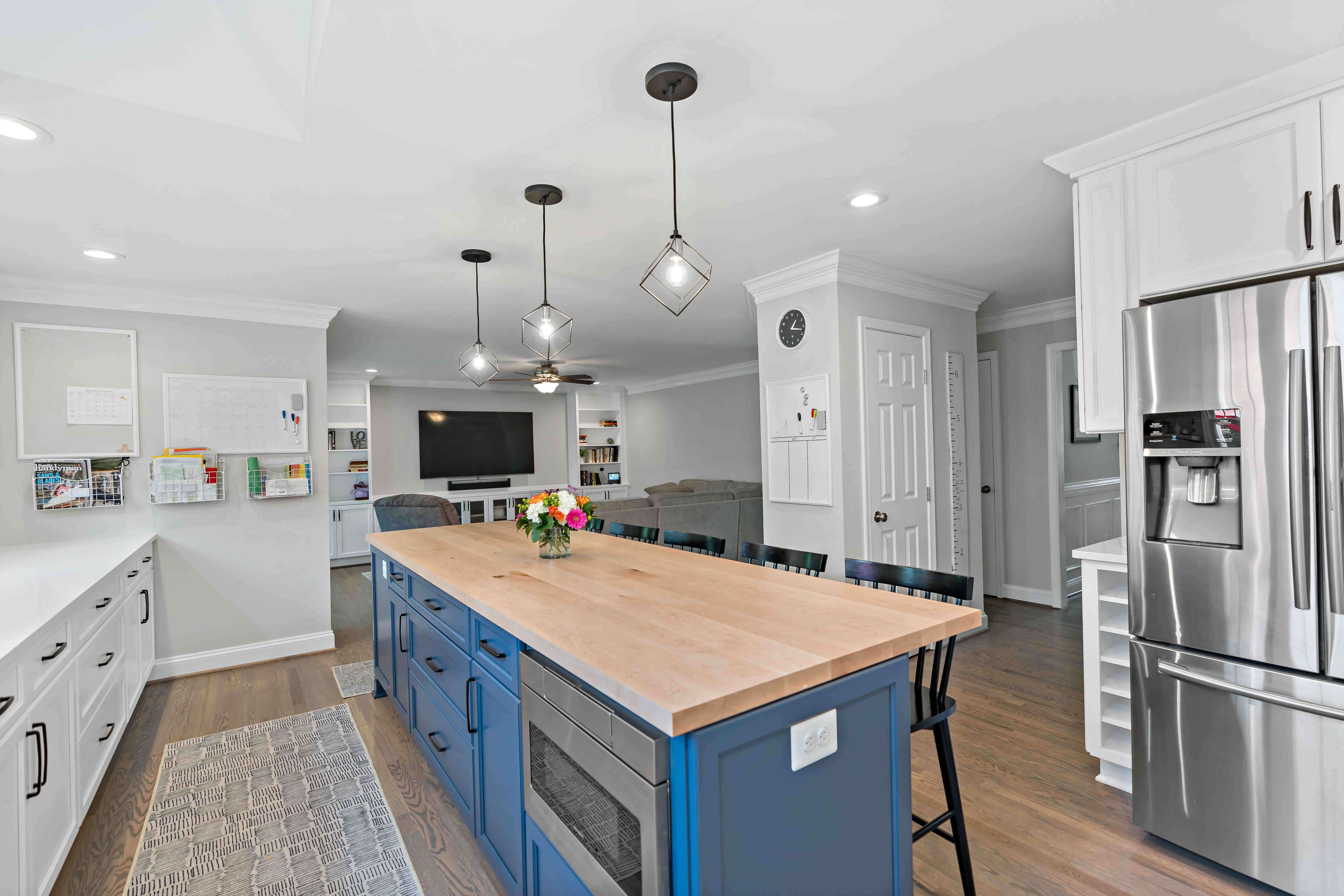 Blue kitchen island with three pendants for lighting above