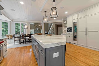 Unique shaped kitchen island in farmhouse design and shiplap ceiling