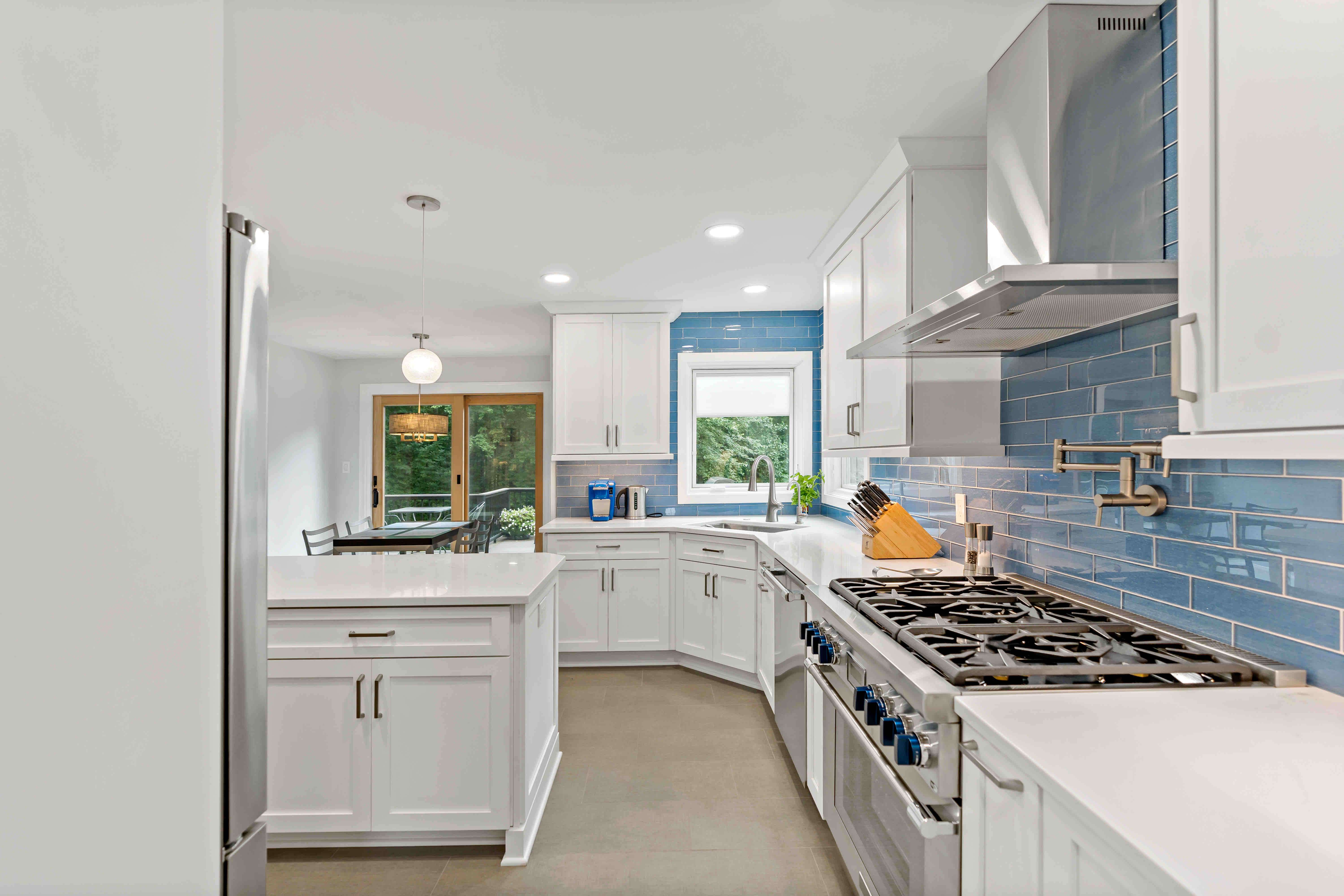 Blue backsplash kitchen with white cabinets