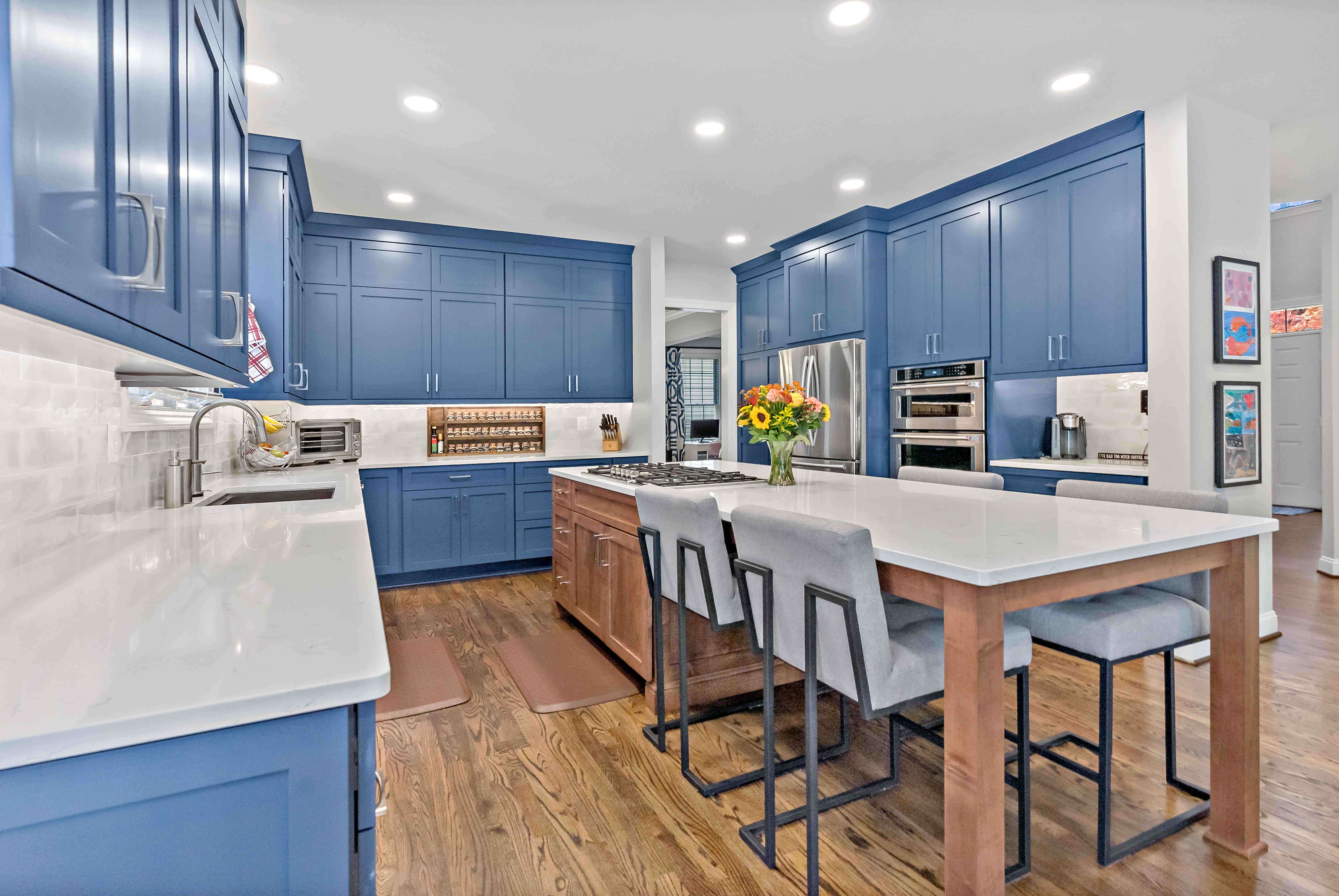 Brown and white kitchen island with grey chairs