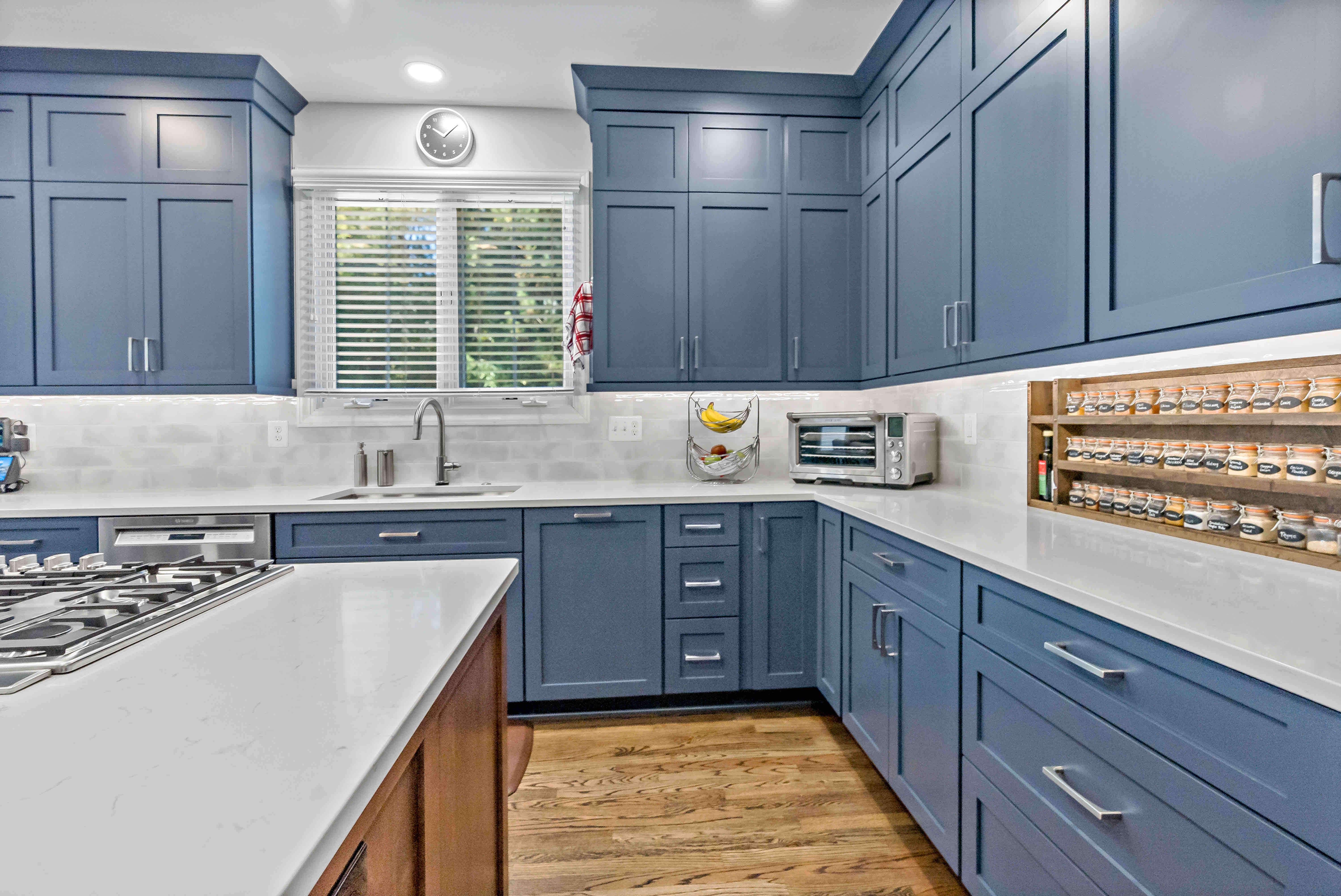 White backsplash and countertops with blue cabinetry in kitchen