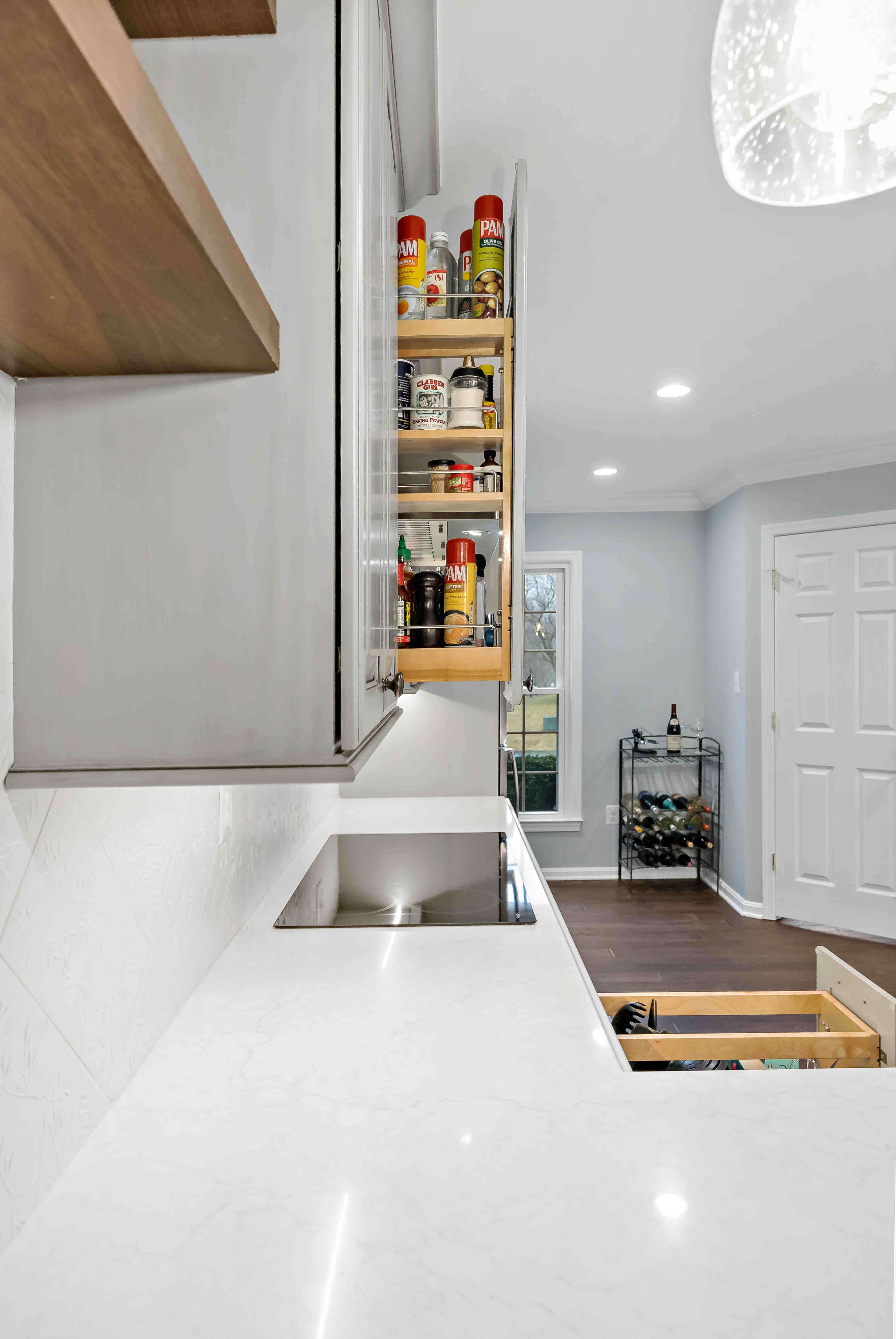 White countertops with custom cabinetry pull-out cabinets for organization