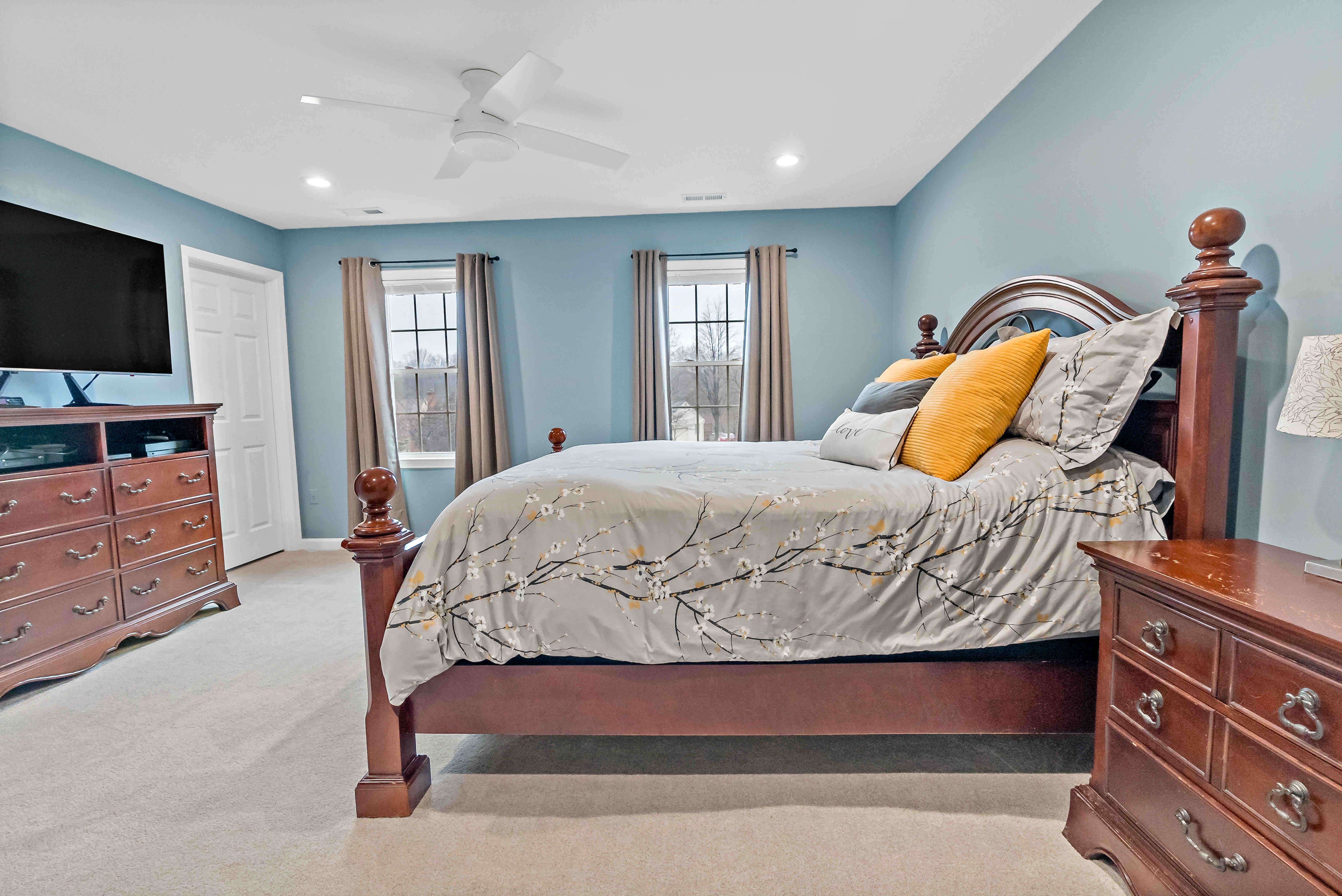 Bedroom with blue walls and beige window curtains