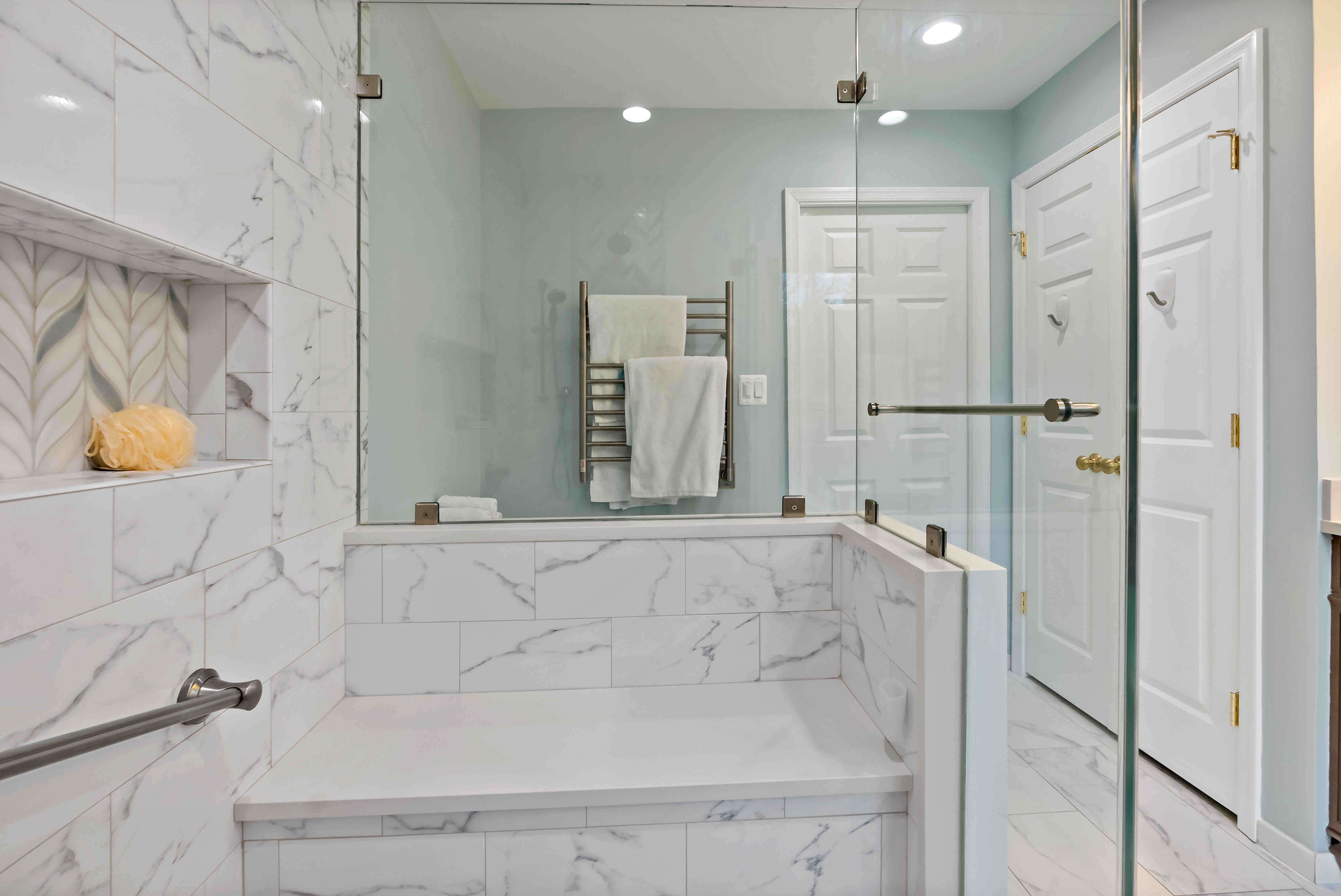 Marble shower tile with bench and glass walls