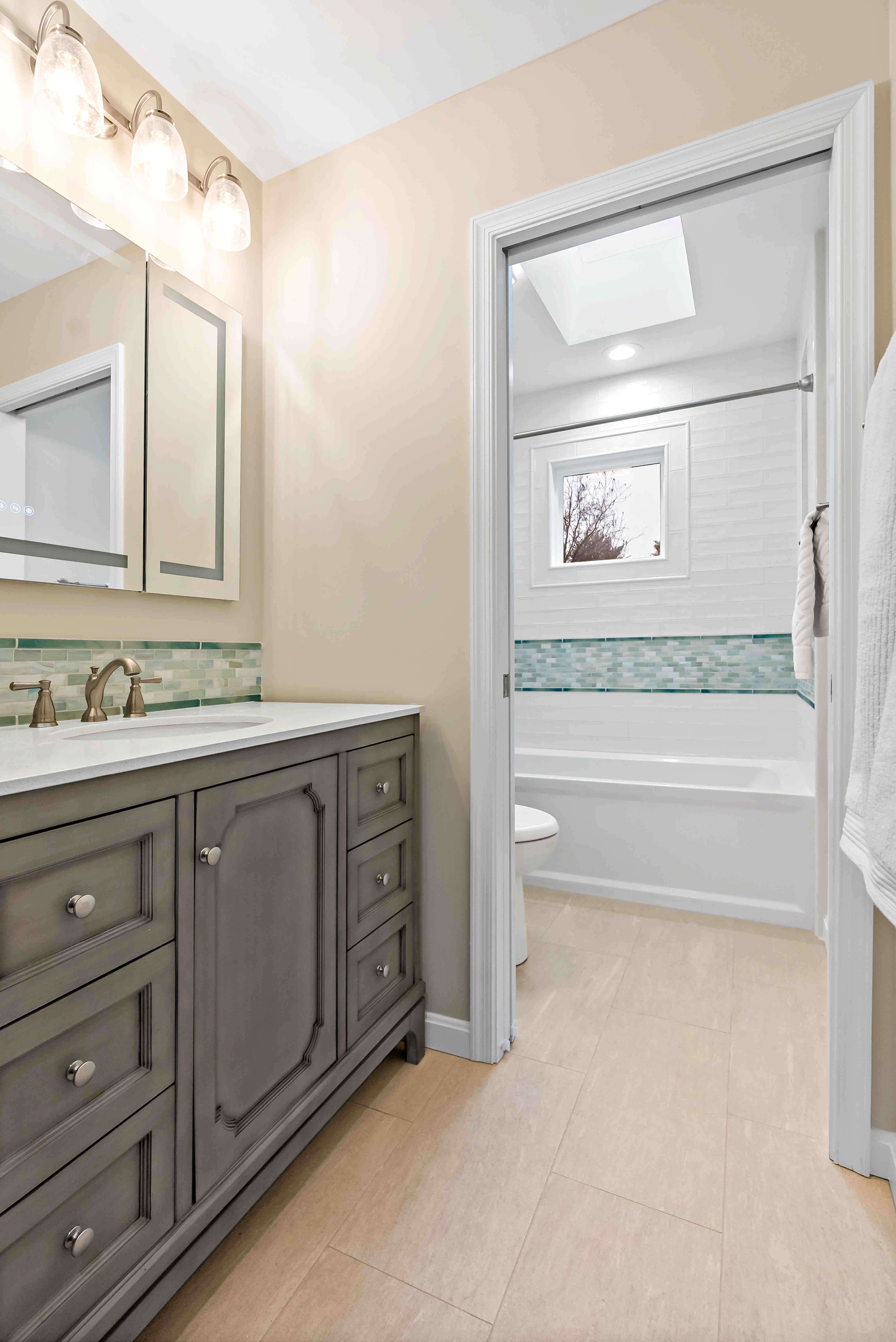 Bathroom with grey cabinets and light orange walls
