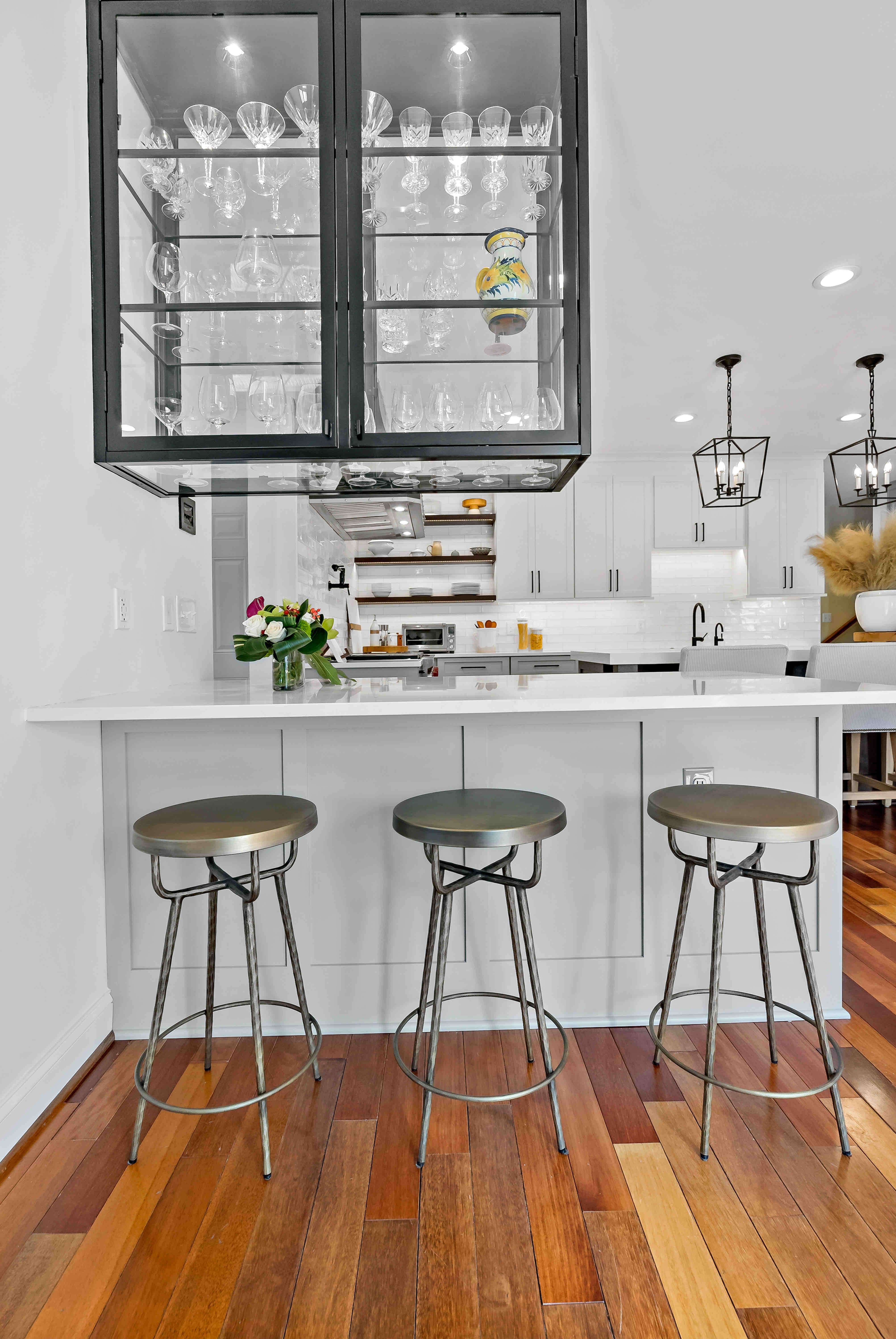 Bar stool seating at kitchen island with glass cabinets