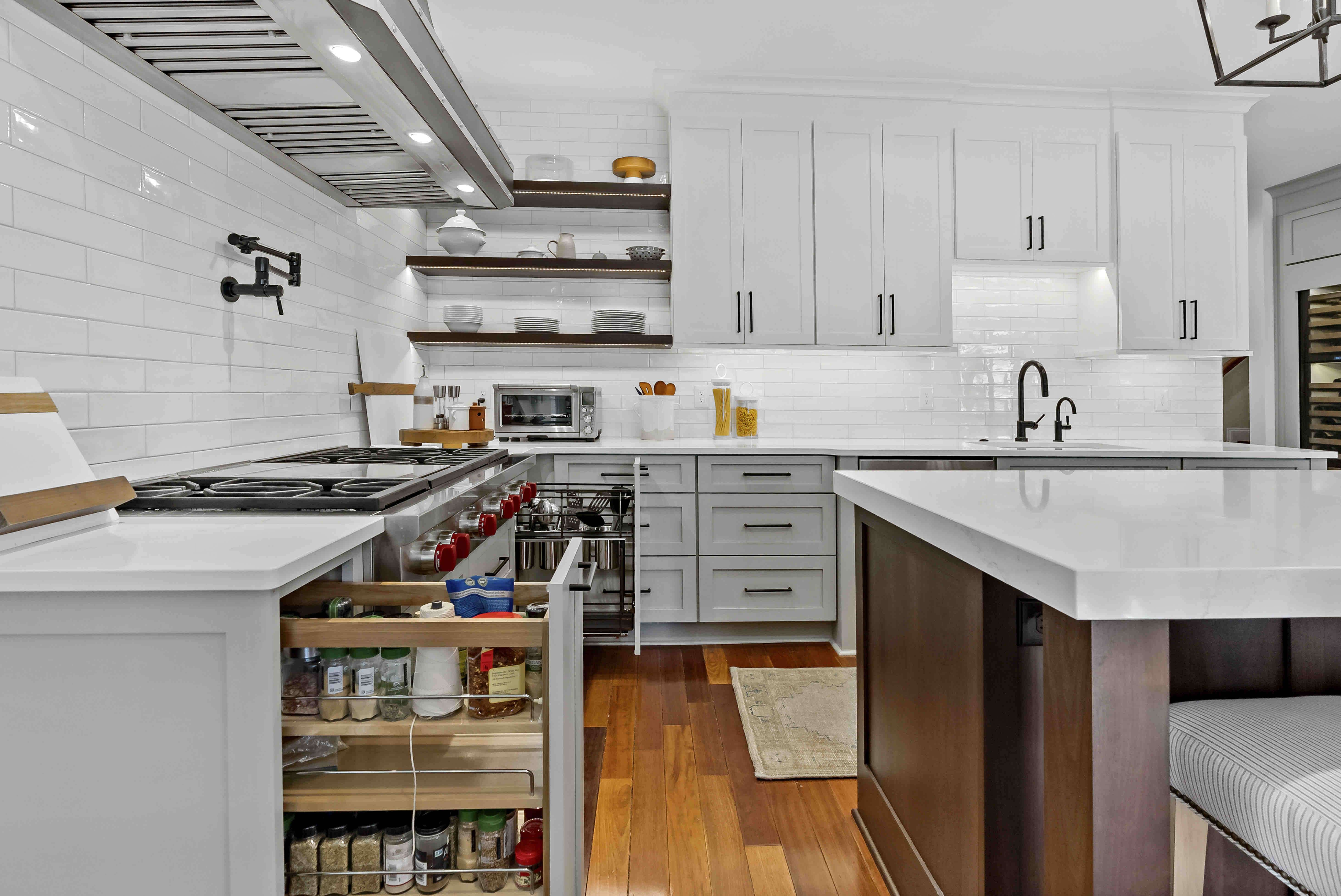 Pot filler by stove and white tile backsplash