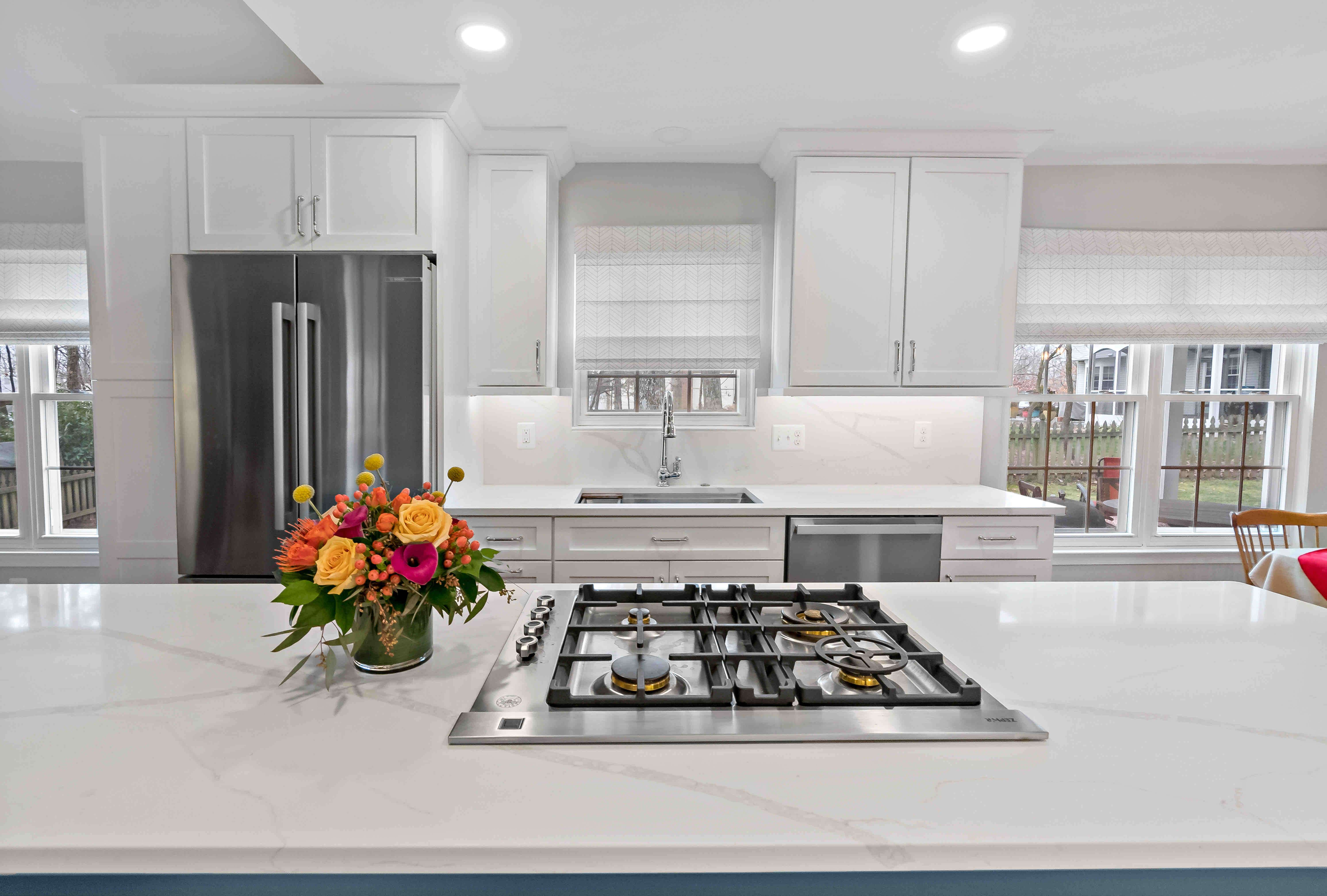 Gas stove on white countertops island in white kitchen