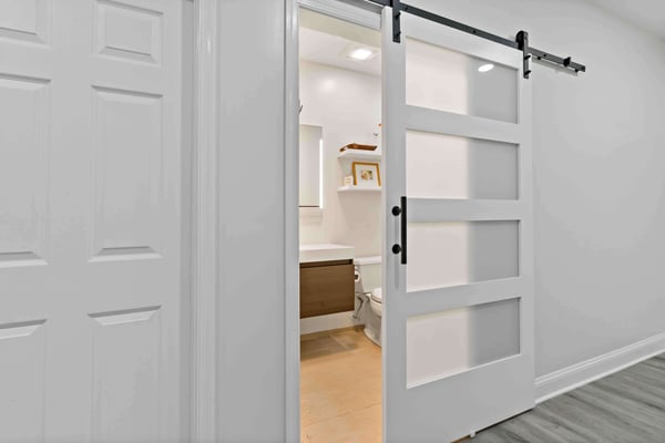 White sliding barn door for bathroom in basement