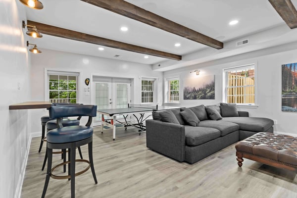 Exposed wood beams and floating bar in McLean basement