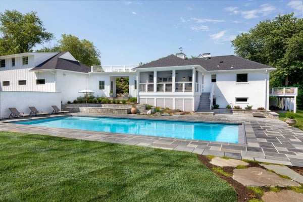 Backyard pool with stone tile perimeter and screened in porch