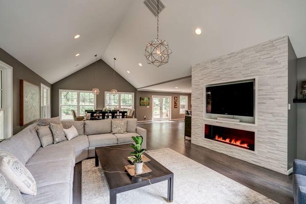 Modern living room with cathedral ceiling and chandelier and electric fireplace