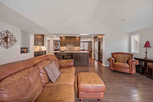 Brown leather sofa in living area next to kitchen