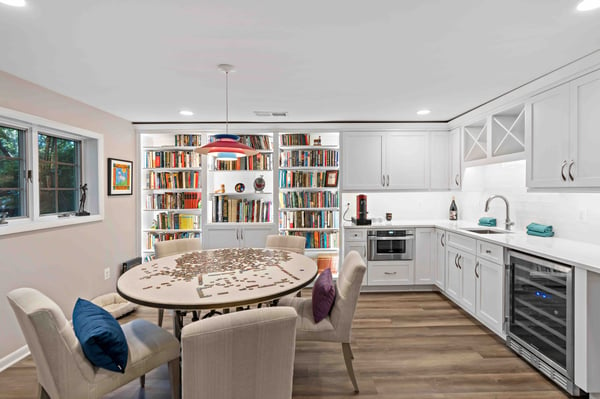 Basement kitchen area with white cabinets and built-in bookshelves