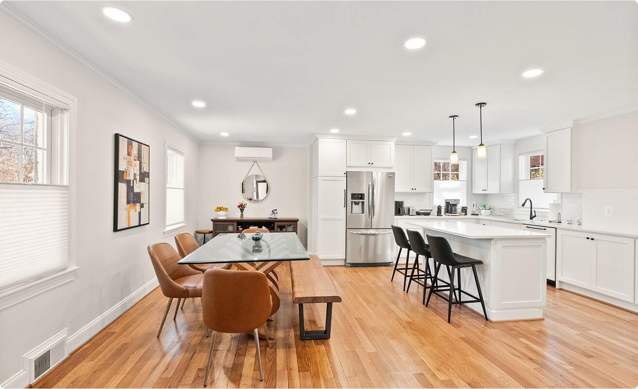 Open concept Arlington kitchen and dining area remodel with white cabinetry, large island, and hardwood floors designed for family gatherings and entertaining.