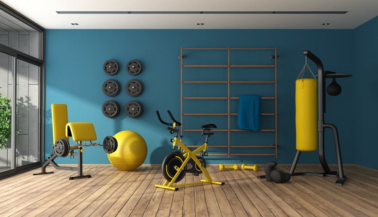 Home gym with yellow equipment and blue walls with glass sliding doors