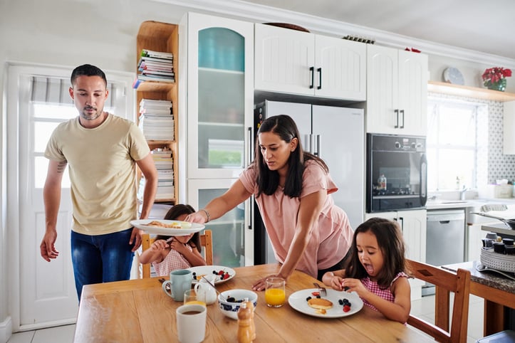 Family eating breakfast in kitchen together as part of their morning routine