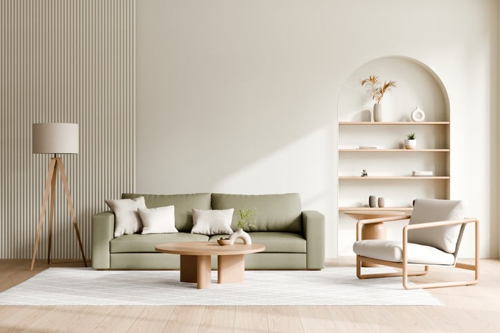 Contemporary living room featuring minimalist design elements, including a green sofa, wooden coffee table, stylish armchair, and wall-mounted bookshelf in earthy tones.
