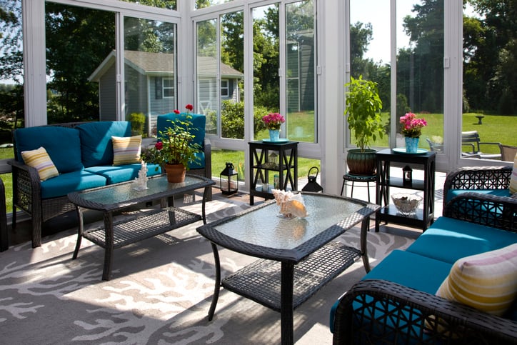 Interior view of a modern sun room with backyard landscape.