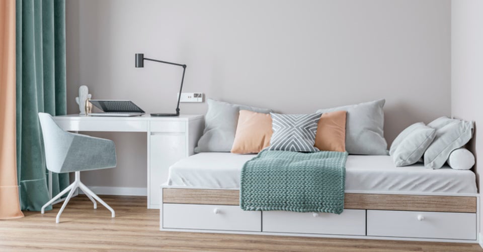 Small but bright room doubles as an office space and a guest bedroom in multi-use space