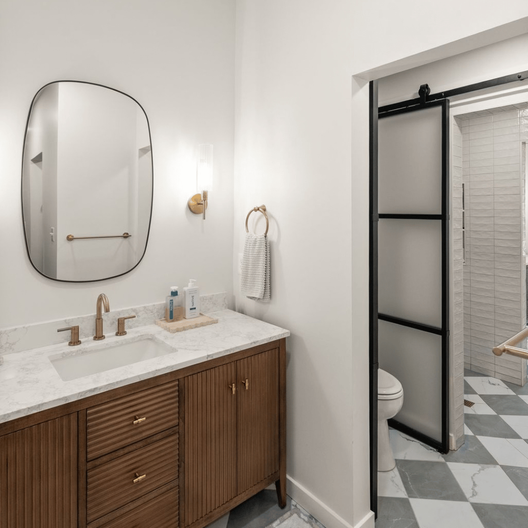 After: spa-inspired bathroom with gold fixtures and sliding barn doors to separate each space