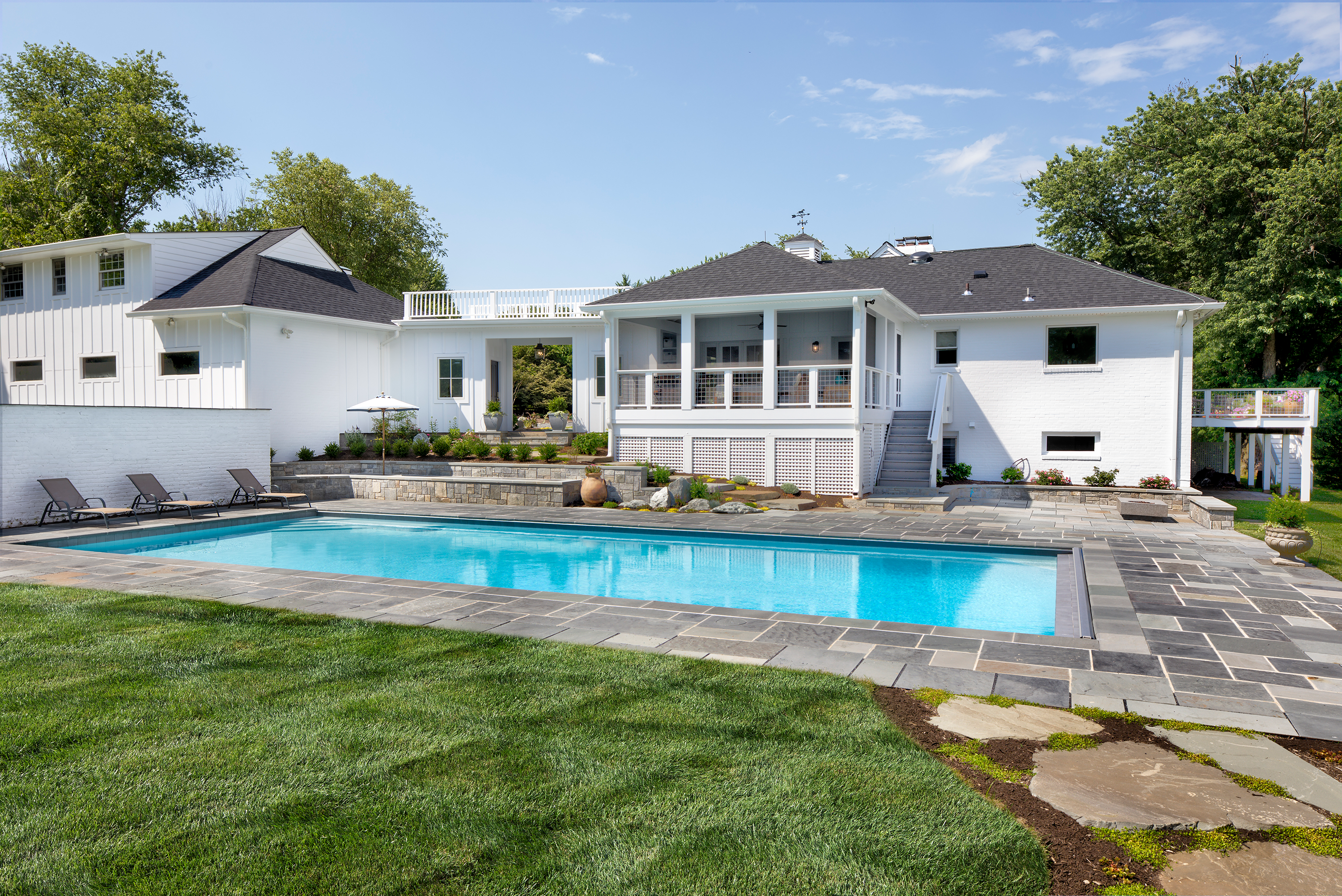 Backyard inground pool with grey tile around pool