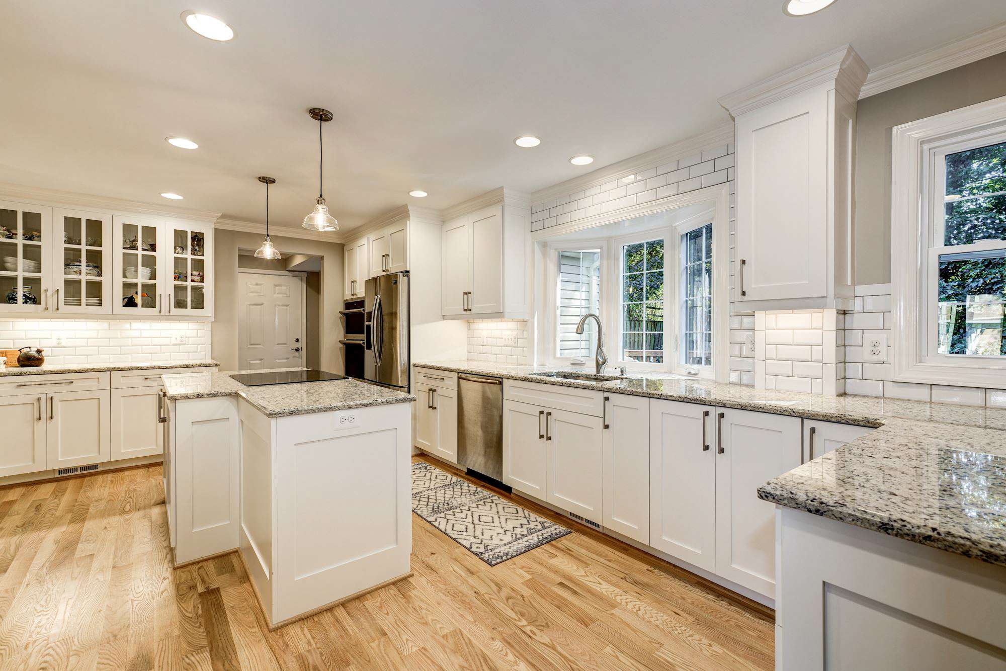 White kitchen cabinets with dark beige granite countertops