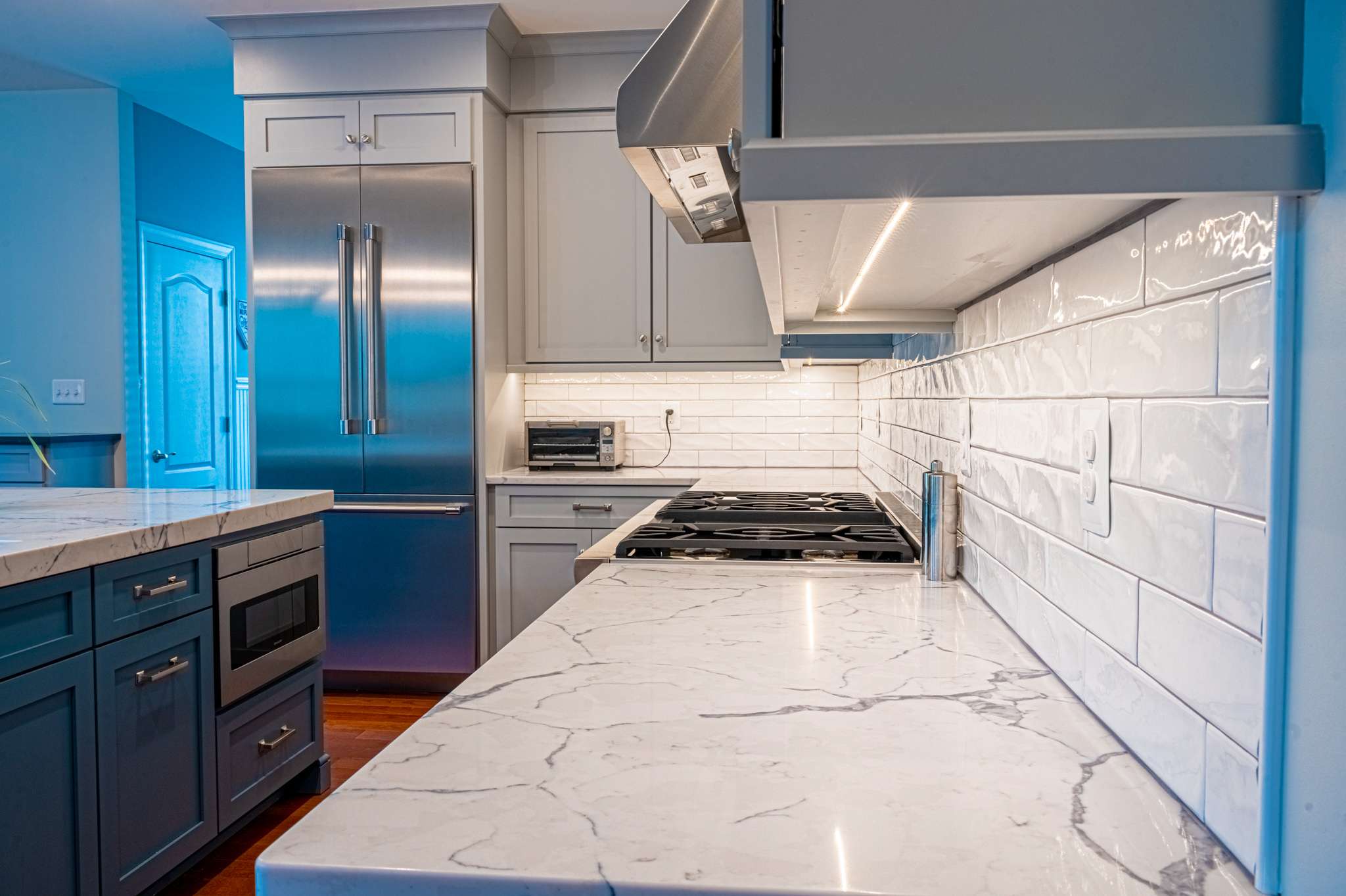 White and black marble countertop with white tile backsplash in kitchen