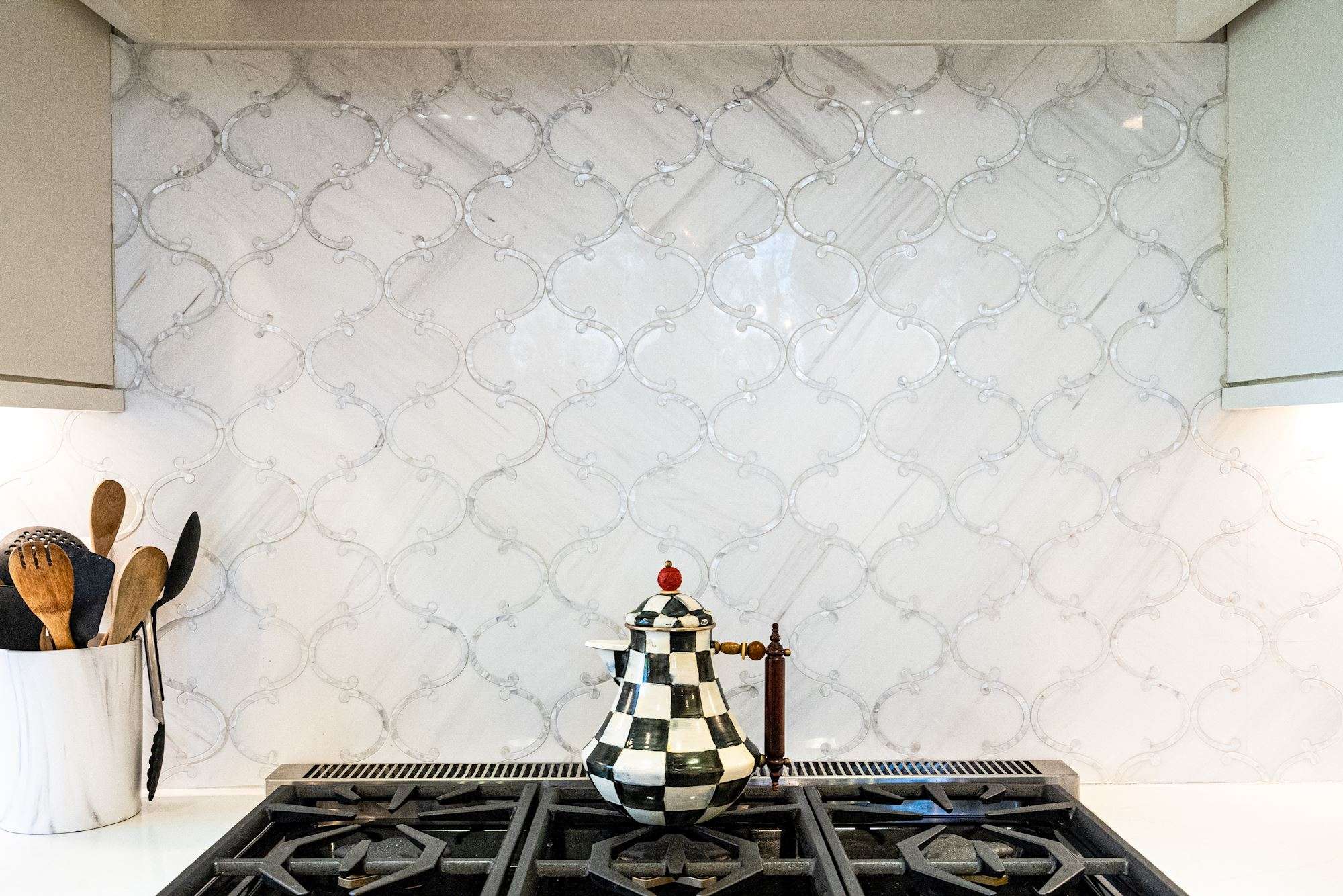 Gas stove top with off-white oval backsplash