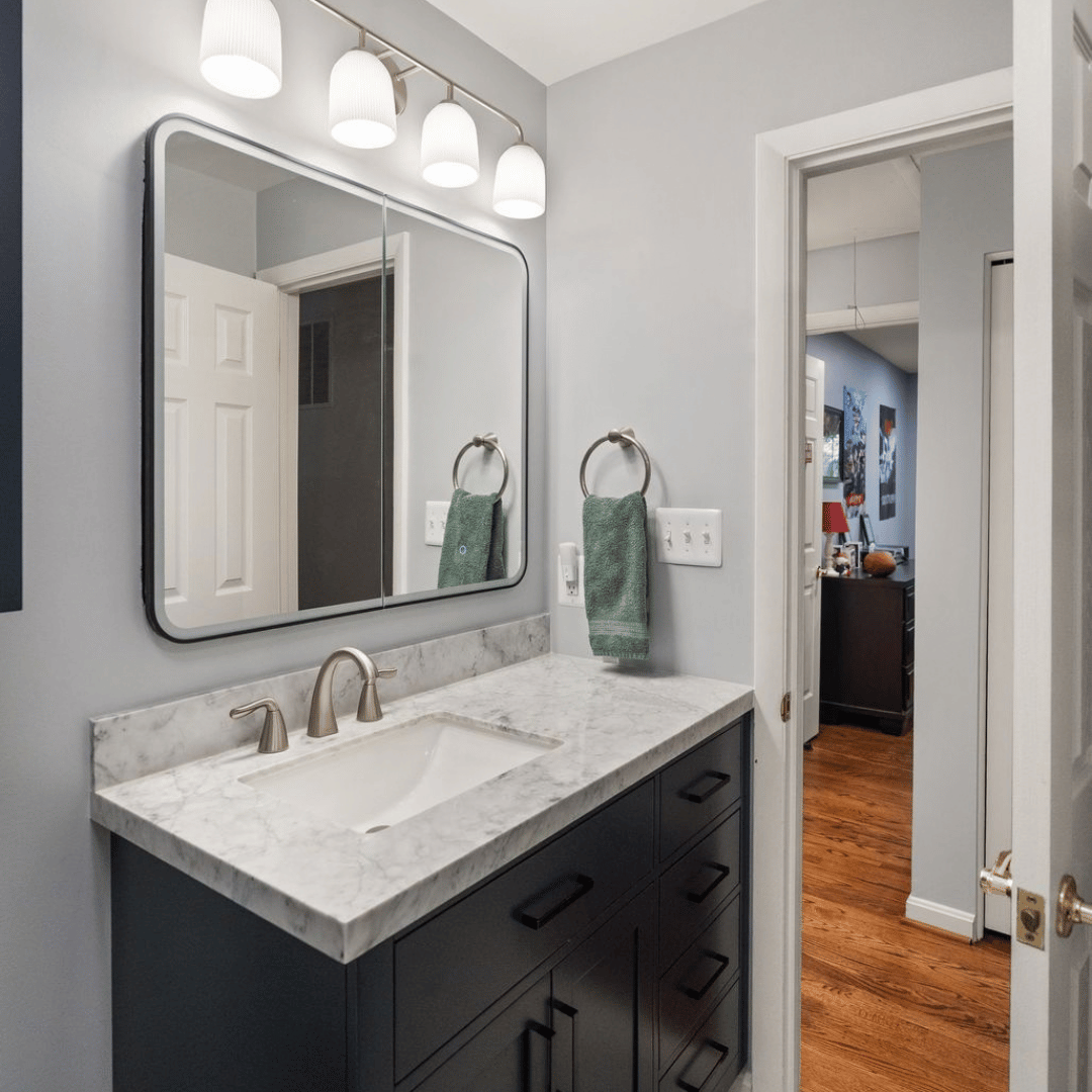 Refreshed hall bathroom with dark blue cabinets