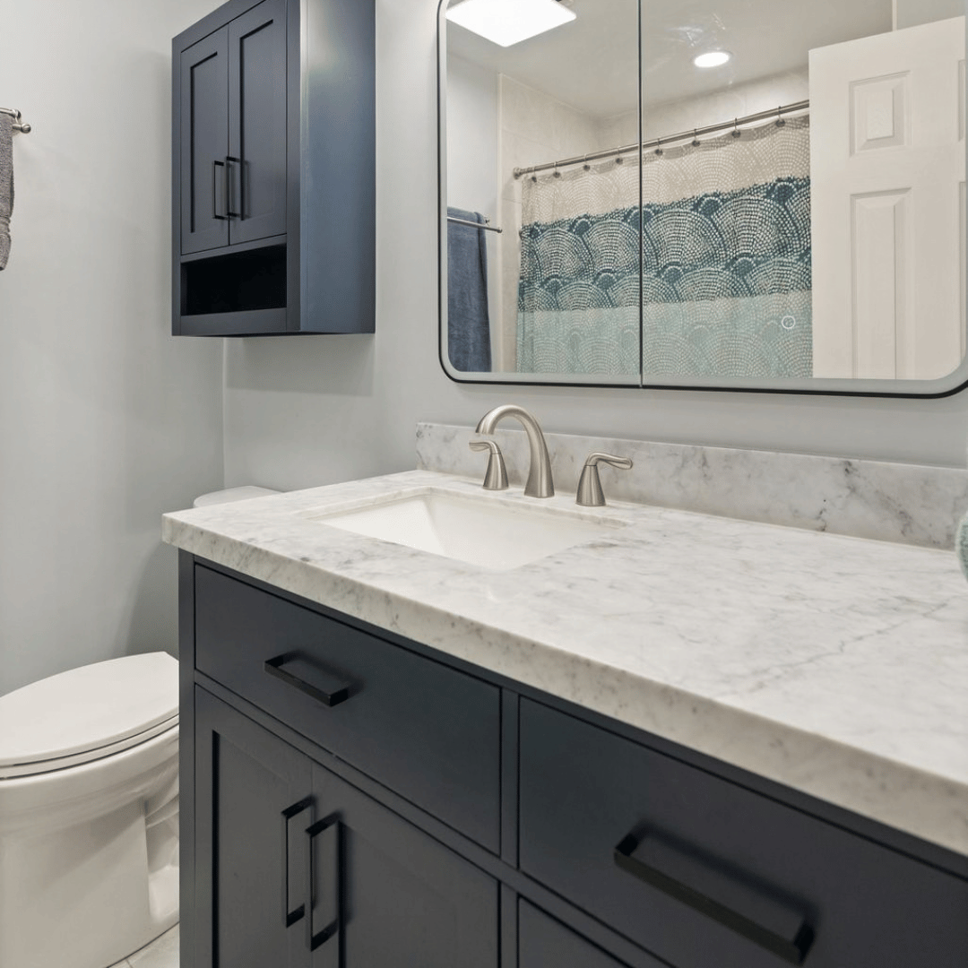 Refreshed hall bathroom with dark blue cabinets