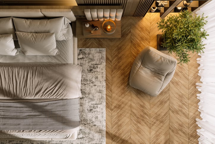 High Angle View Of Modern Bedroom Interior With Bed, Side Table, Armchair And Potted Plant